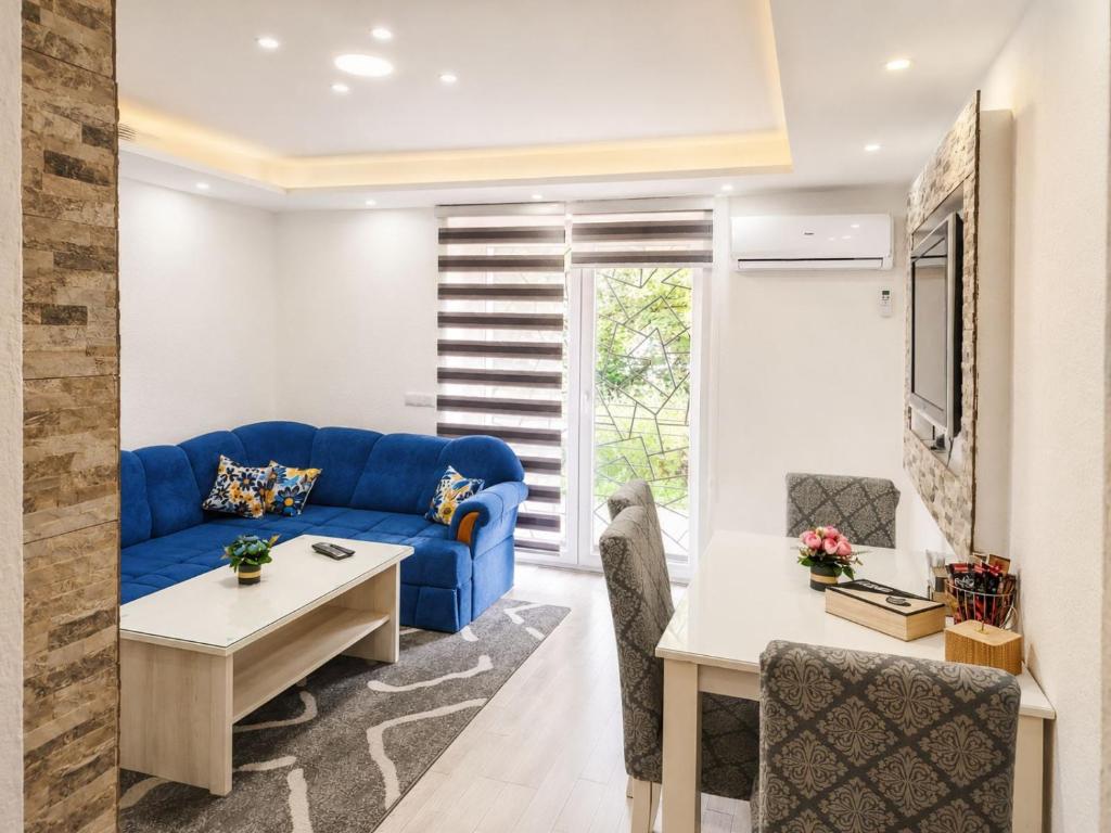 a living room with a blue couch and a table at Apartman Archy in Sarajevo