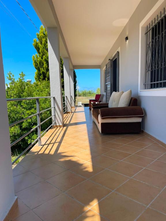 a patio with a couch and a balcony at Mekli Guesthouse in (( Shën Ded Gjoni ))