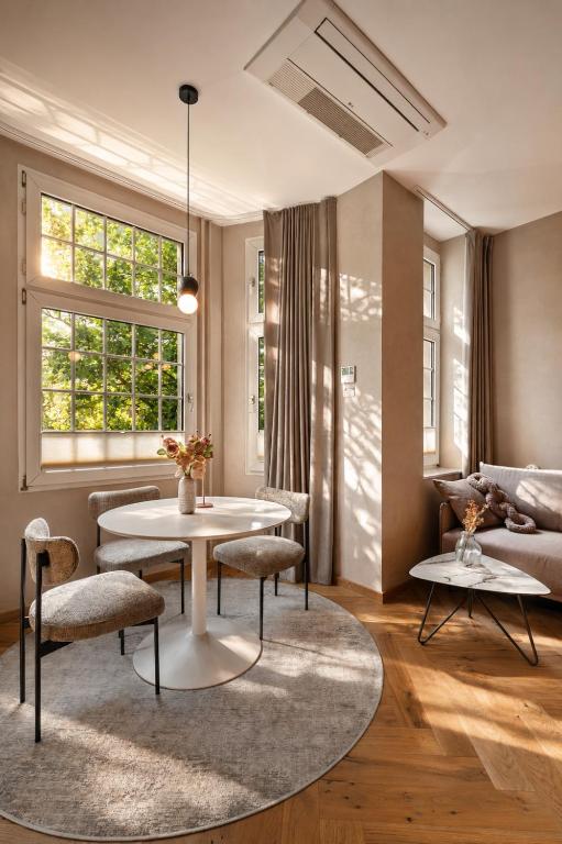 a living room with a table and chairs and a couch at Stylish City Center Escape- Where Modern Elegance Meets History in Trier