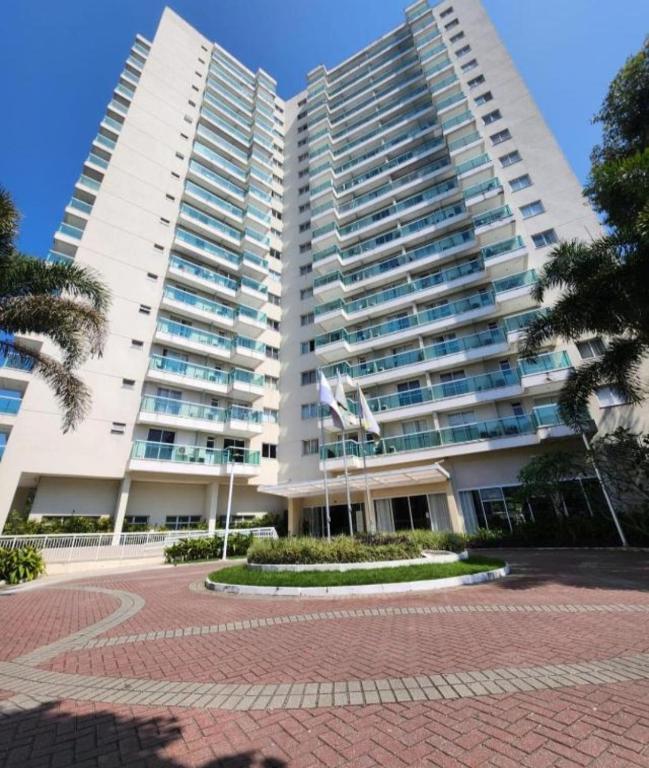 a large white apartment building with two tall buildings at Flat & Suite Premium - Rio Centro - Barra - Farmasi Arena in Rio de Janeiro