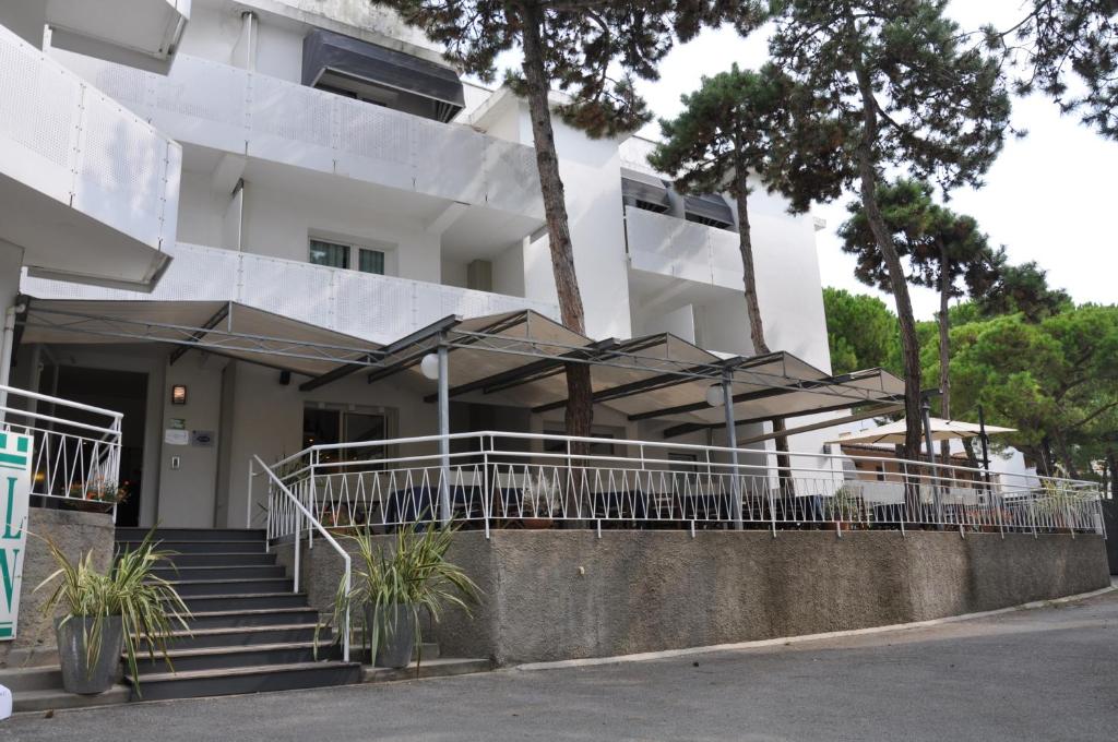 a building with stairs and umbrellas in front of it at Hotel Garden in Lignano Sabbiadoro