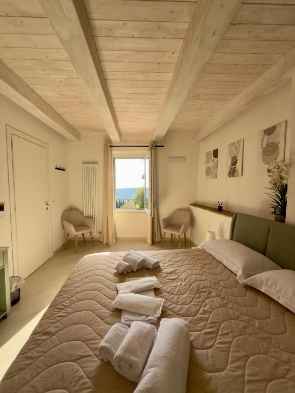 a bedroom with a large bed with towels on it at La Dimora Di Roberta in Montalcino