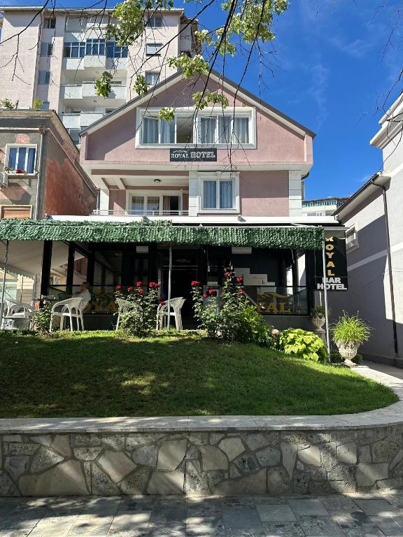 a building with a restaurant with tables and chairs at Royal Hotel Peshkopi Albania in Peshkopi
