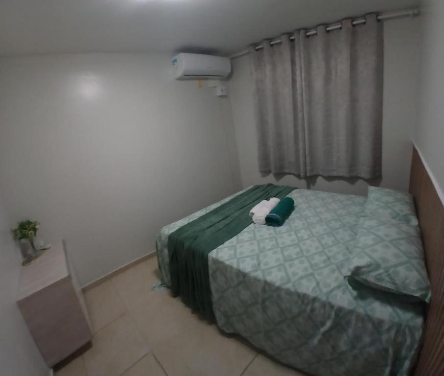 a small bedroom with a bed and a window at Cantinho da Deusa in São José de Ribamar