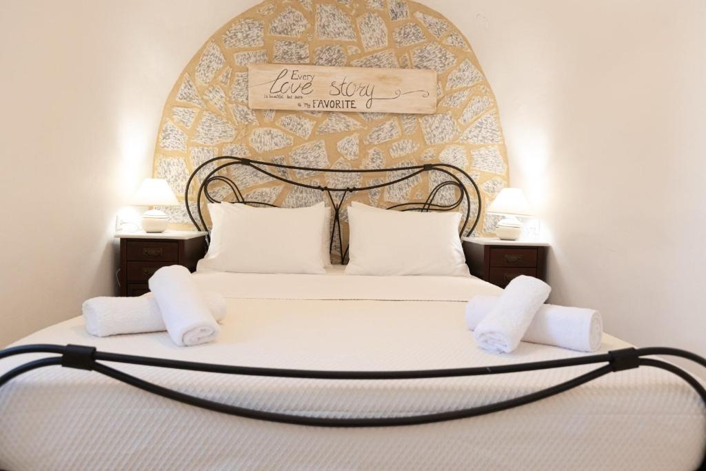 a bedroom with a large bed with a sign on it at Archontiko Koufantonis in Kotronas