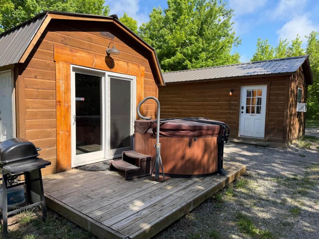 a cabin with a large tub on a wooden deck at The Buck Shack in Elmira