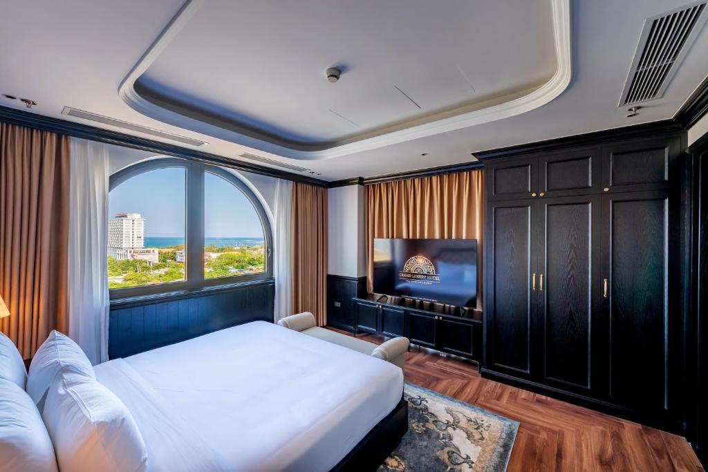a bedroom with a bed and a large window at Grand Luxury Hotel Ninh Chử in Thôn Mỹ Phước