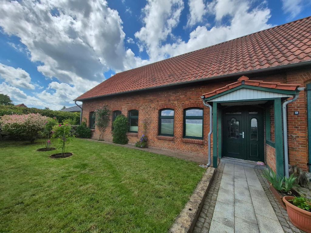 a brick house with a green door and a yard at HAUS 13 in Upahl
