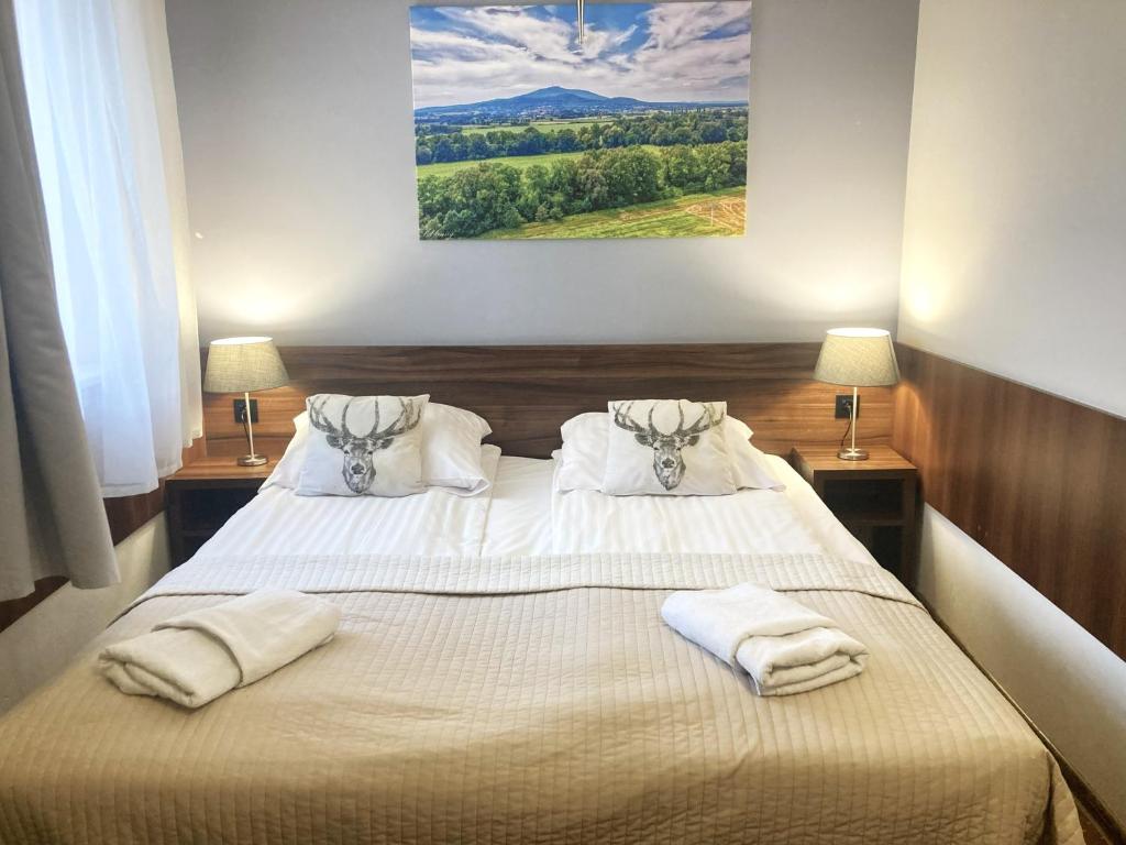 a bedroom with a bed with two towels on it at Hotel Pod Jeleniem in Sobótka