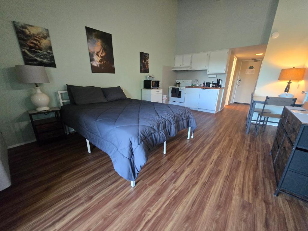 a bedroom with a bed in the middle of a room at Cedar Lodge Condo with Private Balcony & Full Kitchen in Laconia