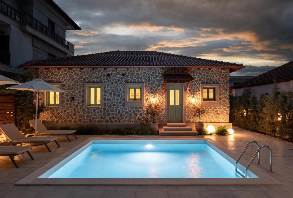 a swimming pool in front of a house at Pnoe Luxury Villa - Private Pool Retreat & BBQ in Ierissos