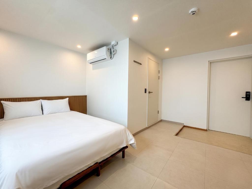 a bedroom with a white bed and a closet at 아문 스테이 in Busan
