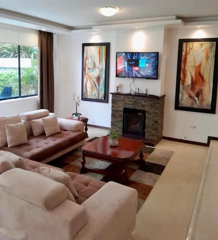 a living room with a couch and a fireplace at Hospedaje en Quito Norte, Apartamento & Suite independientes in Quito