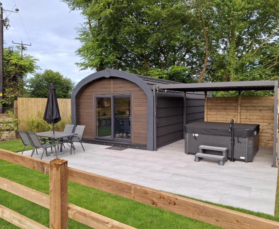 a backyard patio with a gazebo and a grill at Blackstairs Glamping Pod 1 in Killann