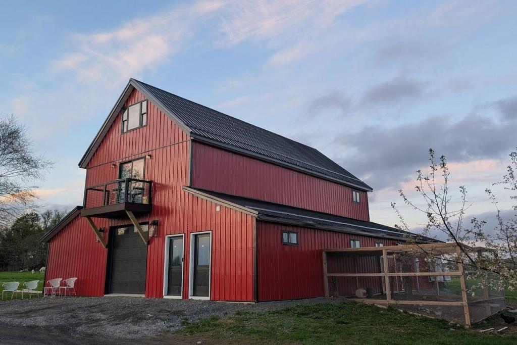 a red barn with a black roof at Scenic Homestead Barndominium in Dryden