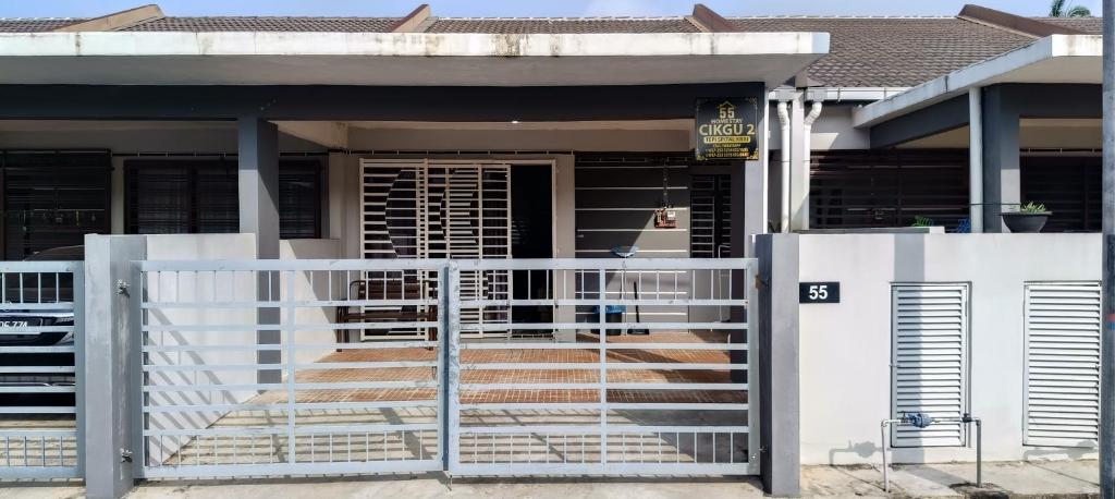 a house with a white fence and a gate at Homestay Cikgu 2 Hospital Kuala Krai in Kuala Kerai