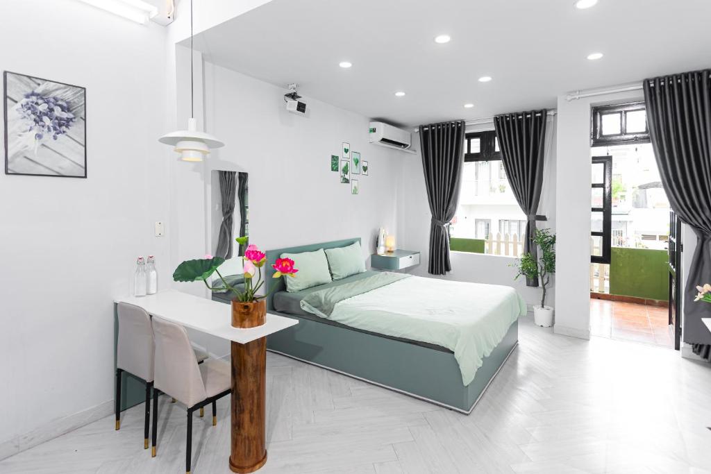 a bedroom with a bed and a table and chairs at Four P Home - Binh Thanh in Ho Chi Minh City