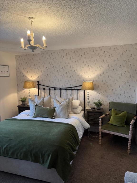 a bedroom with a large bed and two chairs at Bewerley Hall farm in Harrogate