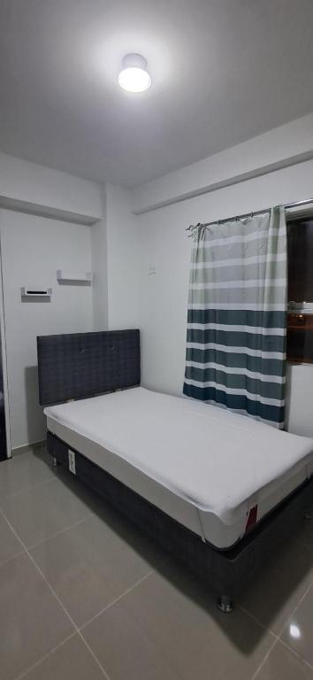 a large bed in a room with a curtain at La torre in Lurín