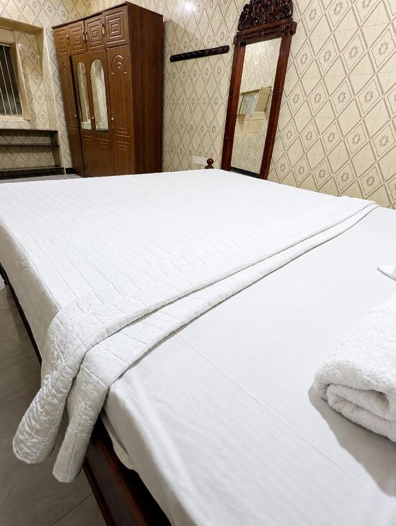 a bed with white sheets and towels on it at Zanzibar stone town house in Zanzibar City