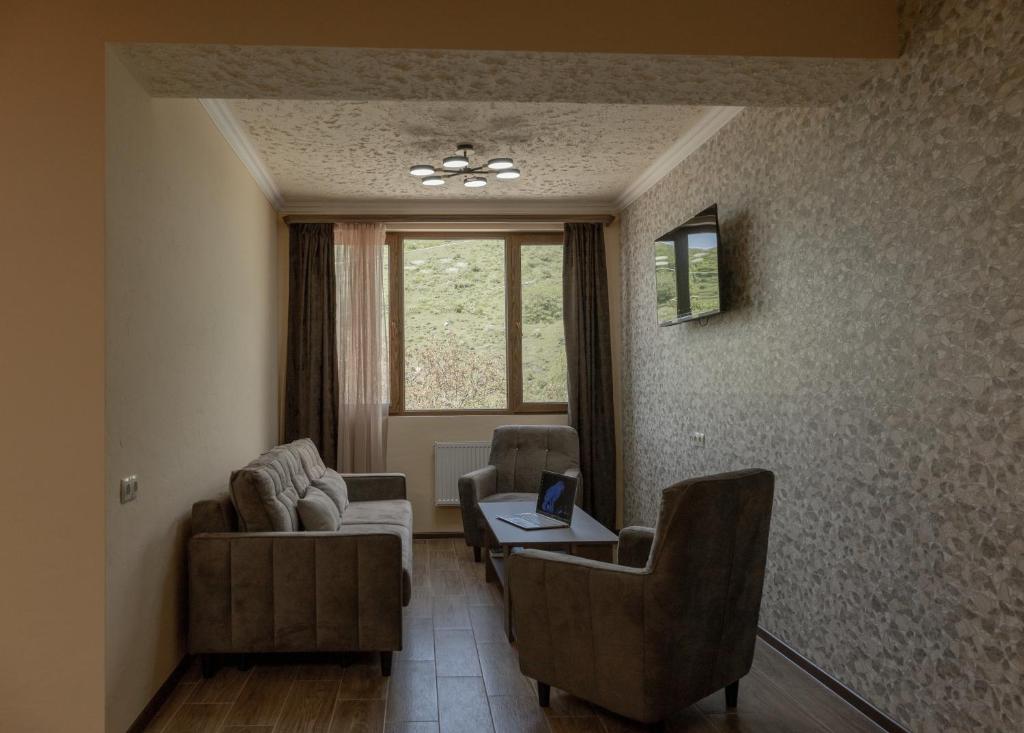 a living room with two chairs and a table at Old House Residence Aghveran & Restaurant in Arzakan
