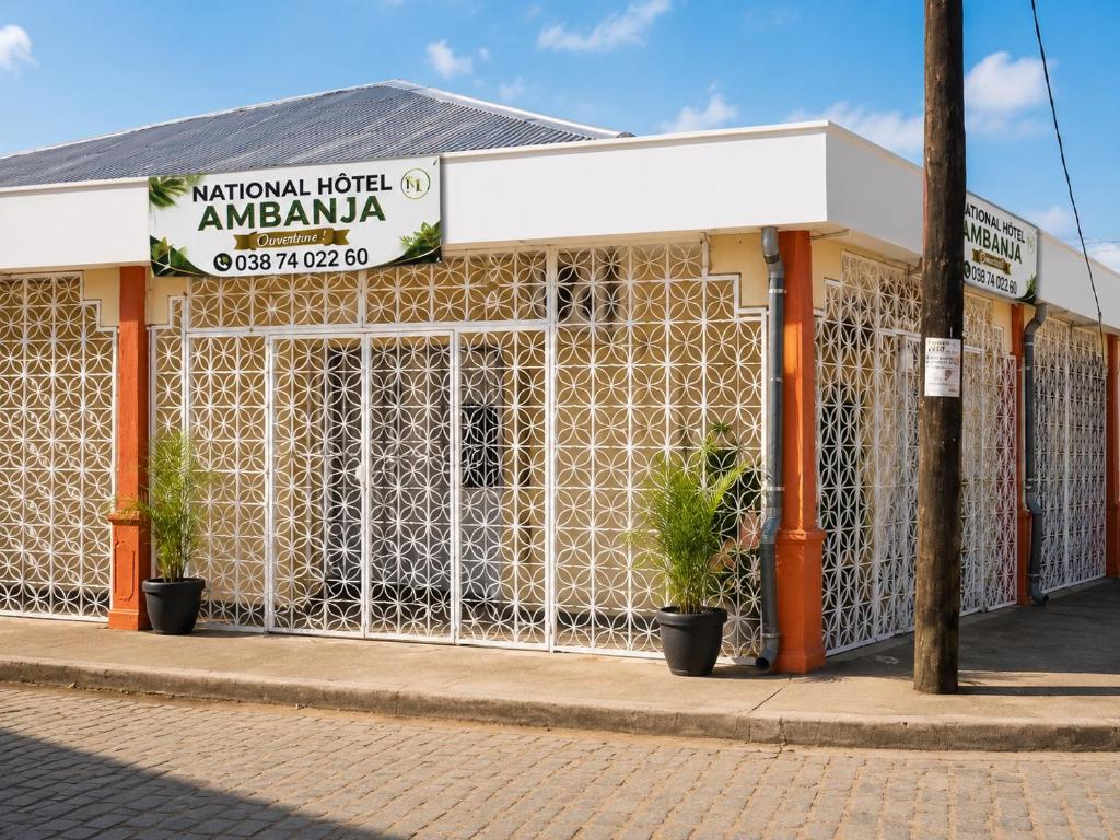 a building on a street with plants in front of it at Hotel National Ambanja in Ambanja