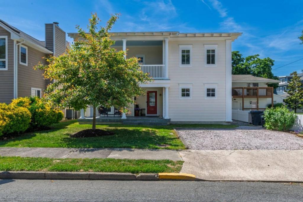 a white house with a tree in front of it at 216 New Castle St, Rehoboth Beach in Rehoboth Beach