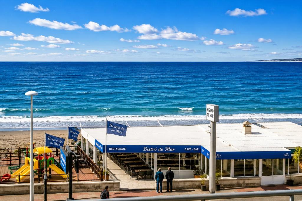 a building on the beach next to the ocean at Departamento Mara in Puerto Madryn