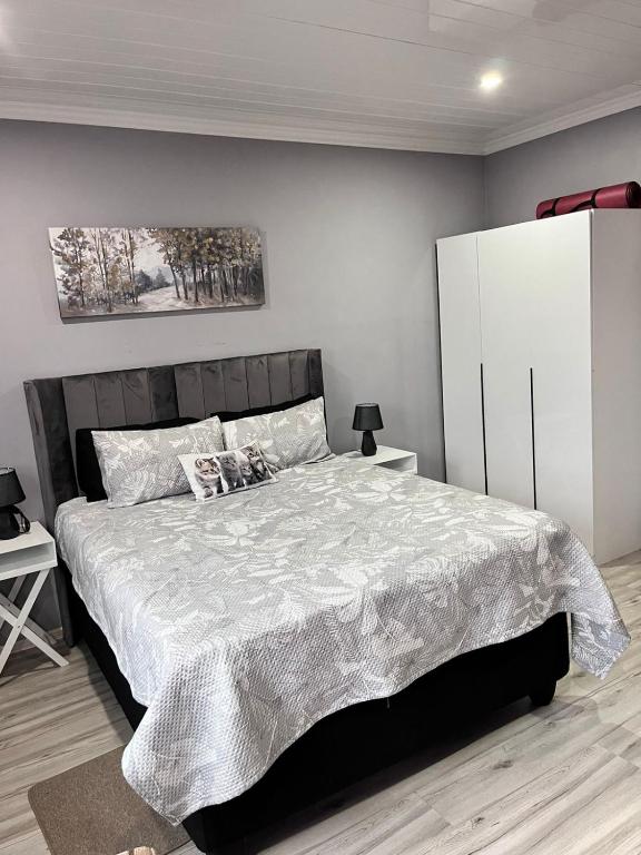 a bedroom with a large bed and a white cabinet at Human on Ten BnB in Summer Pride