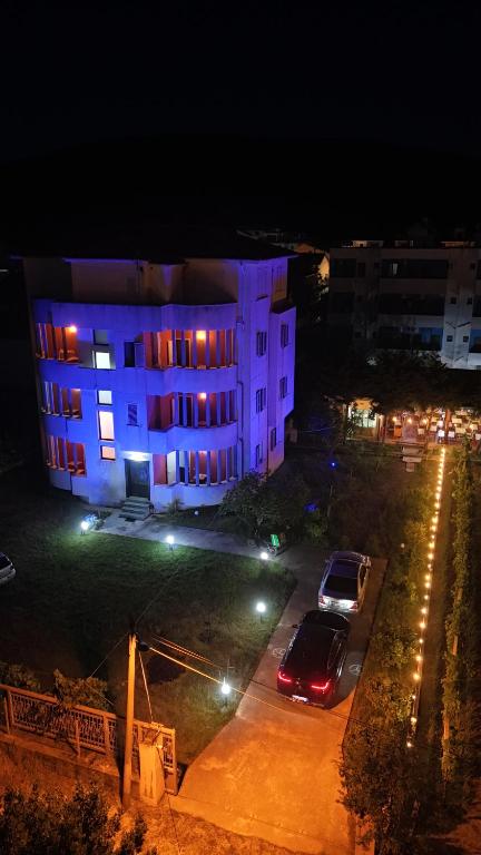 a building with purple lights on it at night at La Famiglia Villa in Velipojë