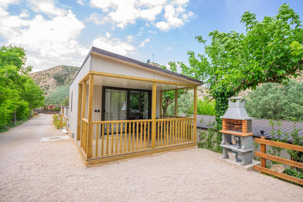 a tiny house with a porch and a grill at Camping Port Massaluca in Pobla de Masaluca