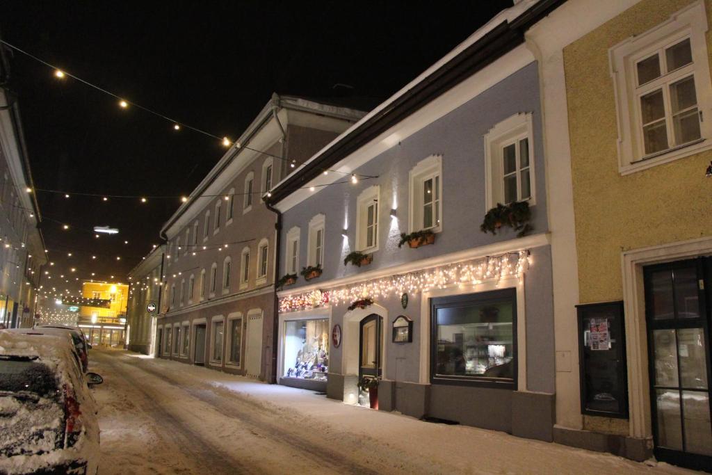 eine leere Straße nachts mit Weihnachtslichtern an Gebäuden in der Unterkunft Stadtappartements Oppeneiger in Radstadt
