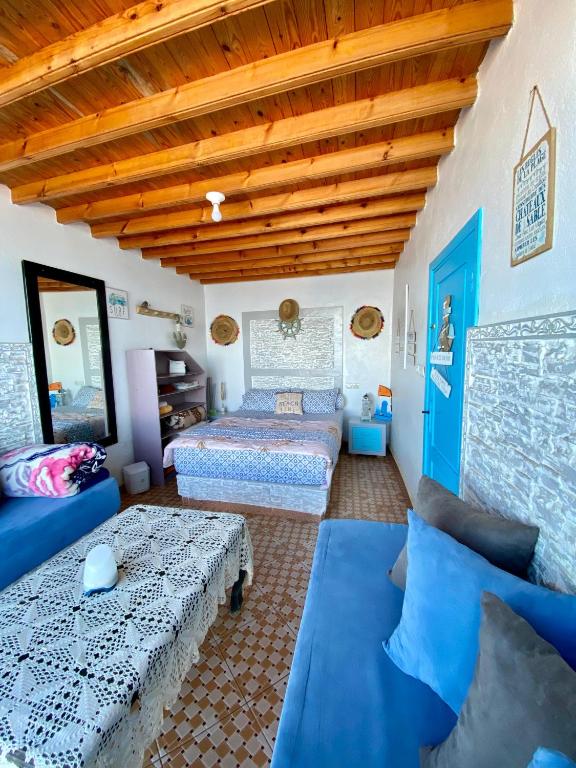 a bedroom with two beds and a wooden ceiling at Grotte pied dans l'eau in Aglou