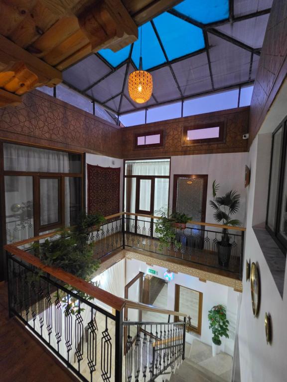 an indoor lobby with a balcony with plants at Shukran hotel in Bukhara