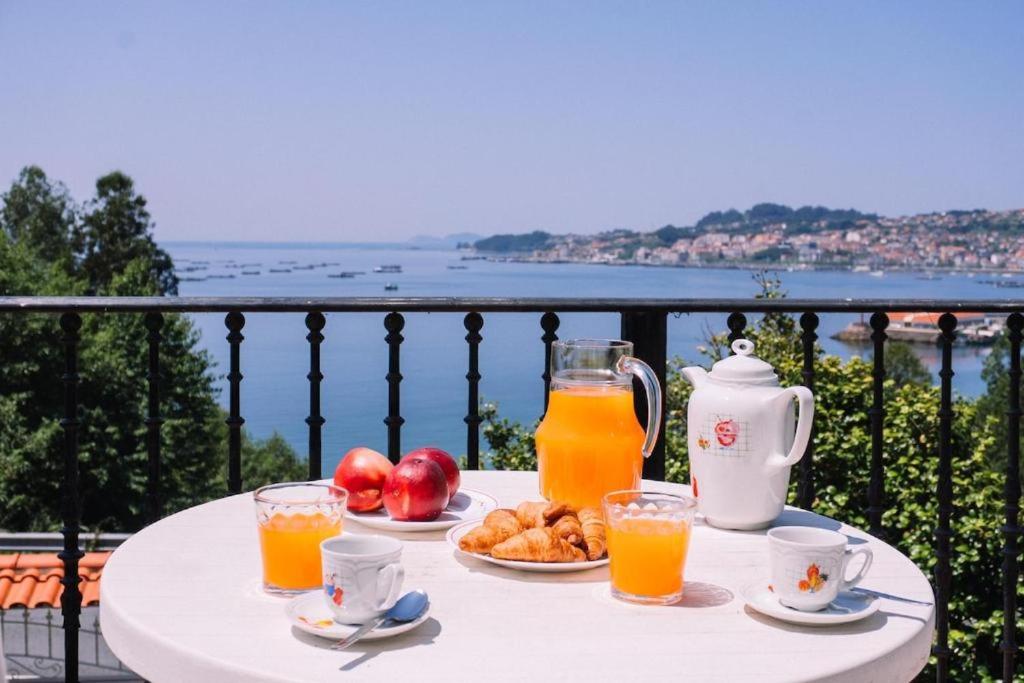 a table with a tray of orange juice and fruit at Casa Meiramar in Moaña