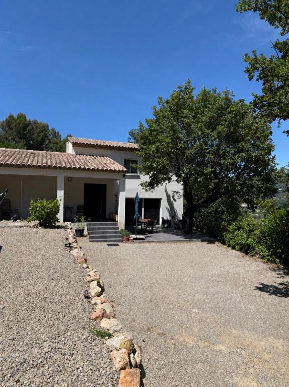a house with a gravel driveway in front of it at Les Jujubiers in Draguignan