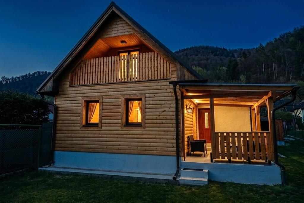 a log cabin with a porch and a balcony at Chata pri Kaštieli - 2 E-bikes in Necpaly