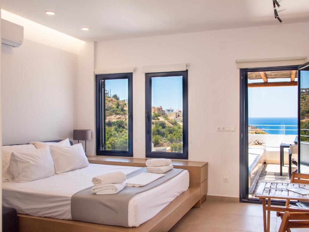 a bedroom with a bed with a view of the ocean at Blue Dawn Kalymnos in Kalymnos