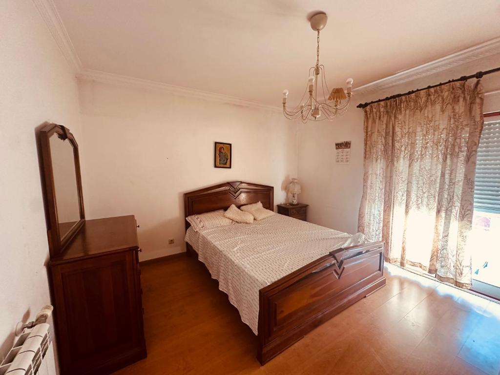 a bedroom with a bed and a chandelier at Rua Gama Barros 22 SUITE in Charneca