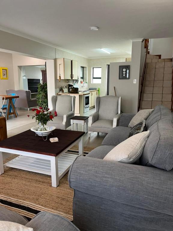 a living room with a couch and a table at River & Salt at Stilbaai in Stilbaai-Oos