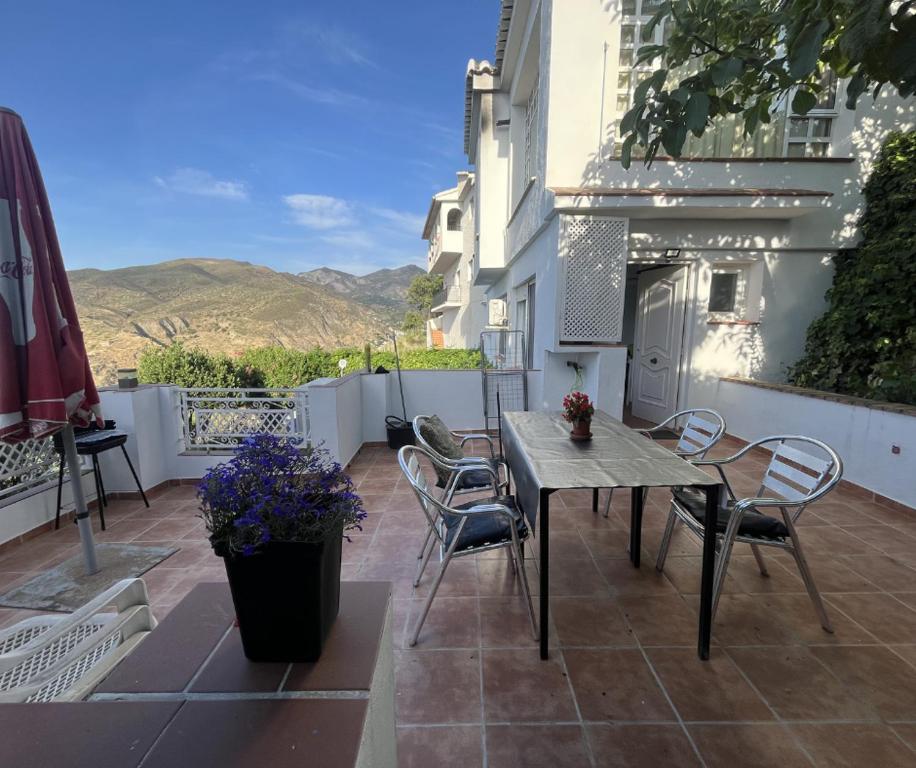 a patio with a table and chairs on a balcony at Alojamiento Colinas in Monachil