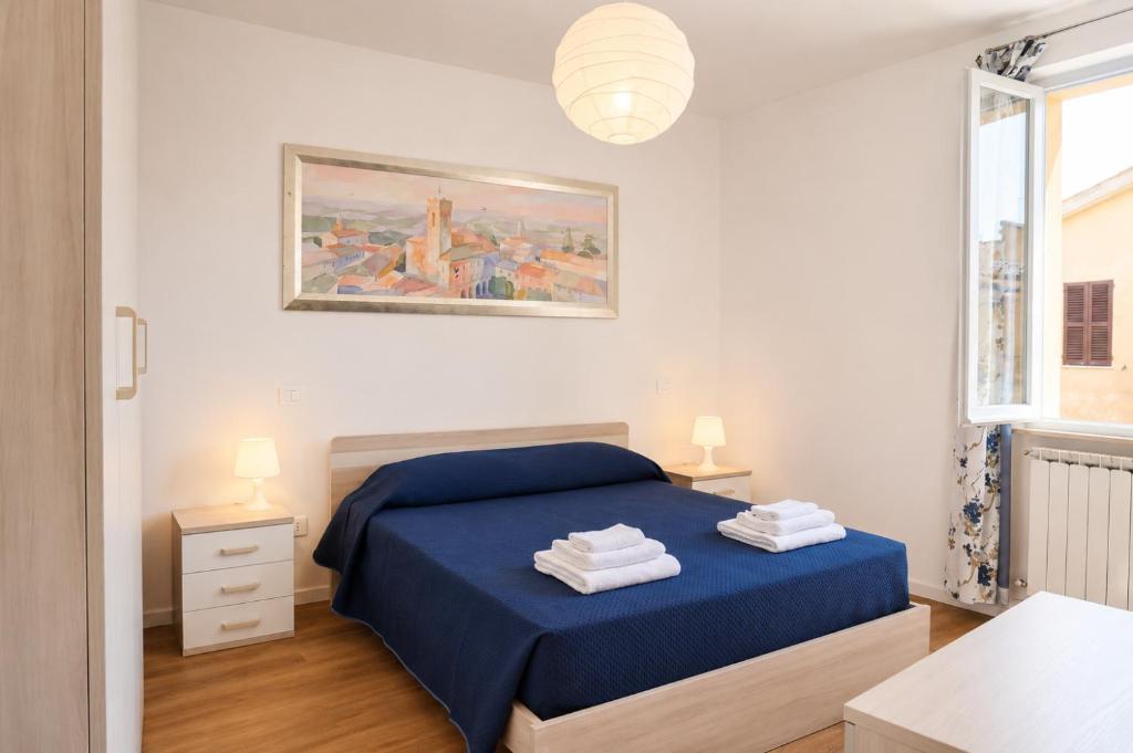 a bedroom with a blue bed and a painting on the wall at La Piazzetta in Cingoli