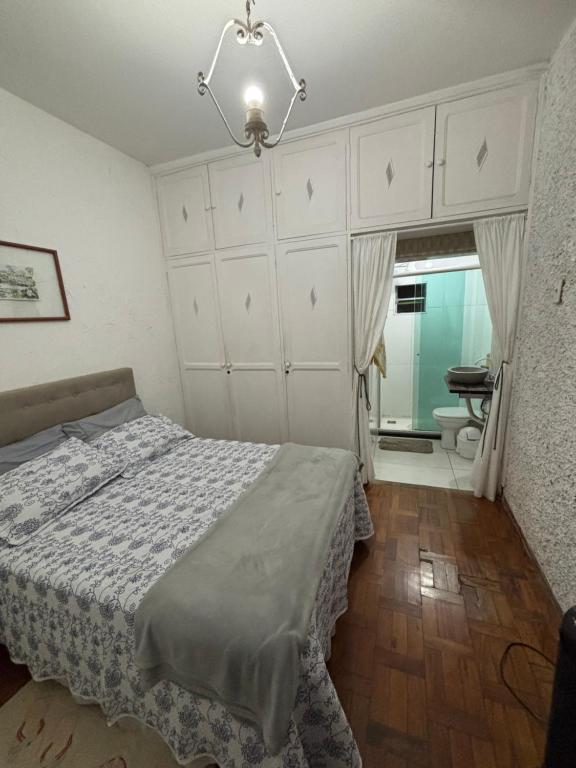 a bedroom with a bed and a bathroom at Quartos Confortáveis em Belo Horizonte in Belo Horizonte