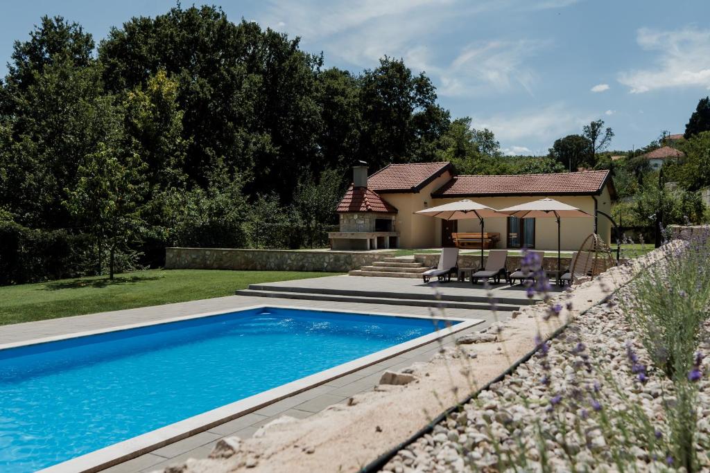 a swimming pool in front of a house at Lastva Nature Retreat in Mostar