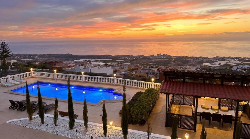 a view of a swimming pool on a building with a sunset at Villa Tequila in Adeje