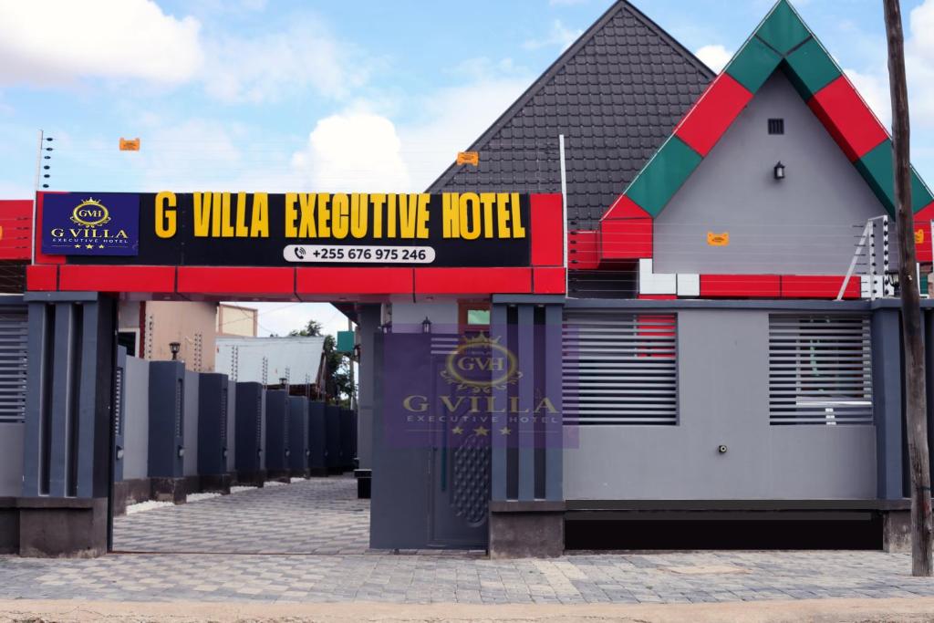 a building with a sign that reads g vill earthquake hotel at G Villa Executive Hotel in Dodoma