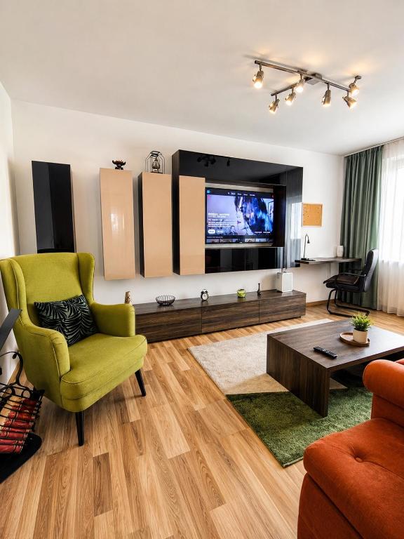 a living room with a green chair and a television at Adrian Home Libra in Ploieşti