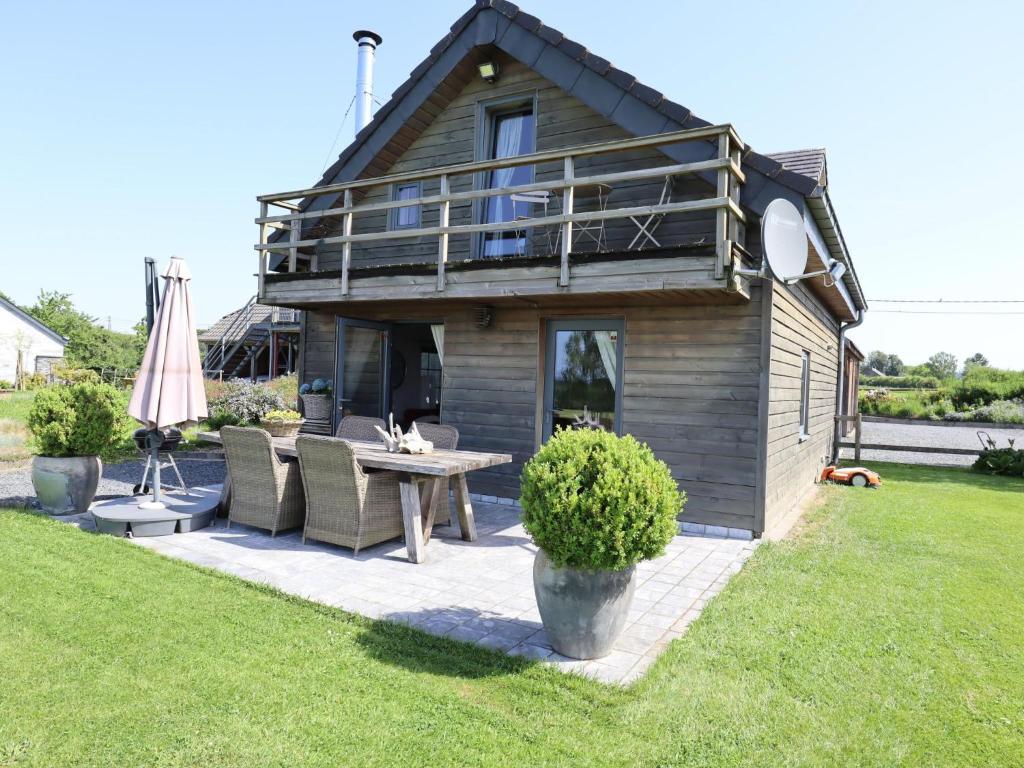 a house with a table and chairs in a yard at Cocoon in Houffalize