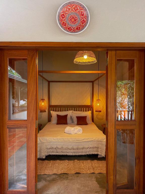 a bedroom with a bed with a canopy at Casa do Rio Âmbar - Alter do Chão in Santarém
