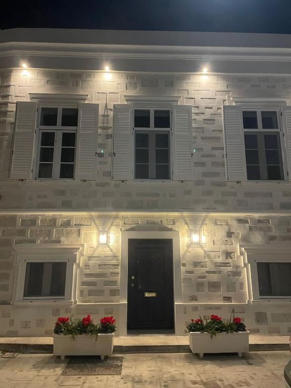 a white brick building with two plants in front of it at Casa Amore in Ermoupoli